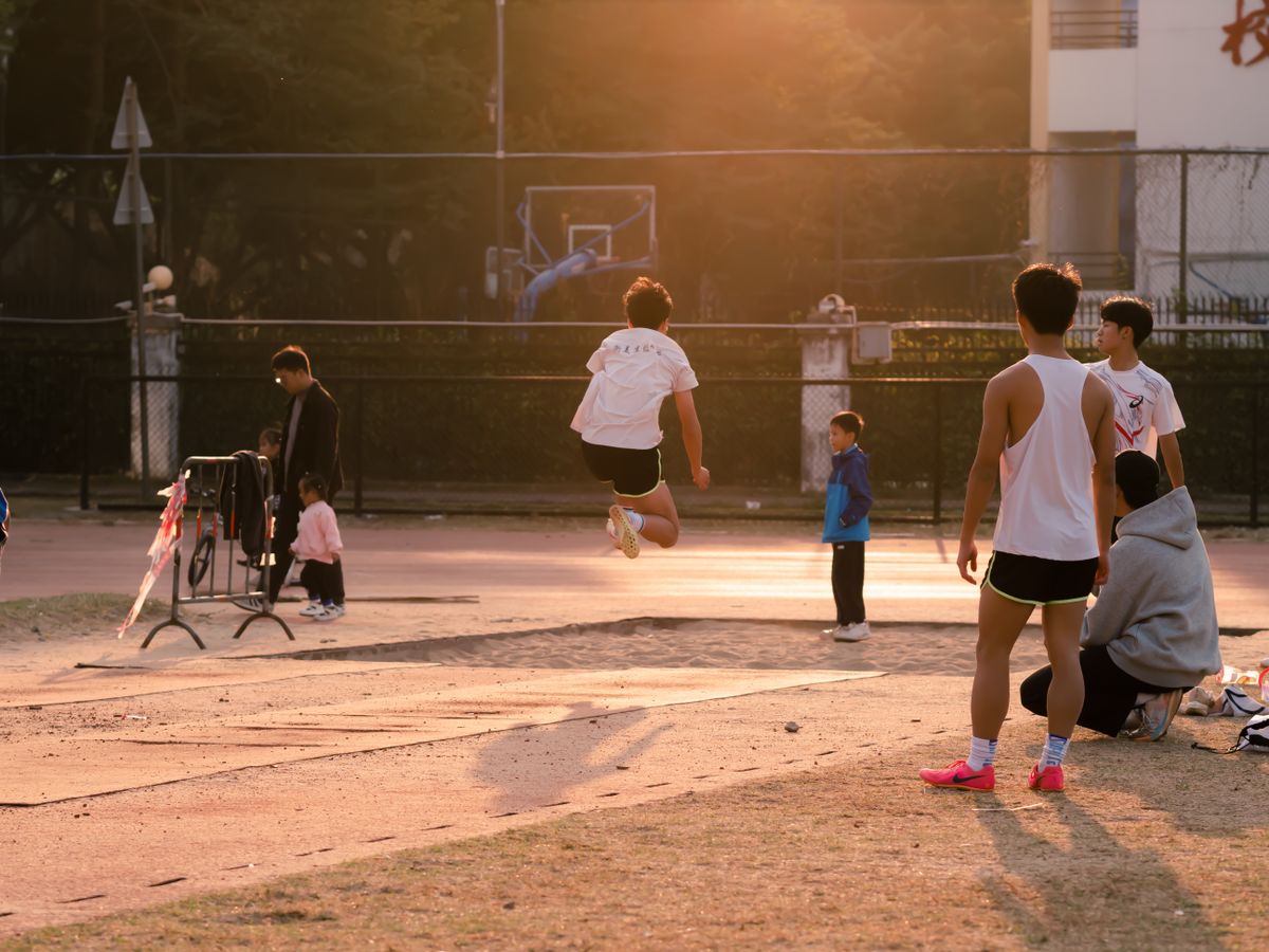 Teenagers jumping in a sunlit school playground